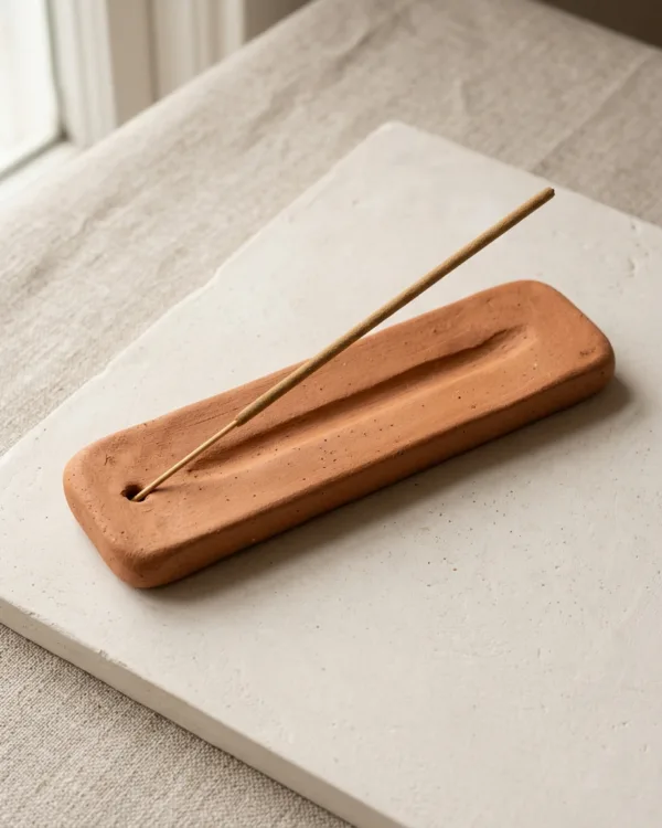 Terracotta clay incense holder with an ash channel and a single unlit incense stick