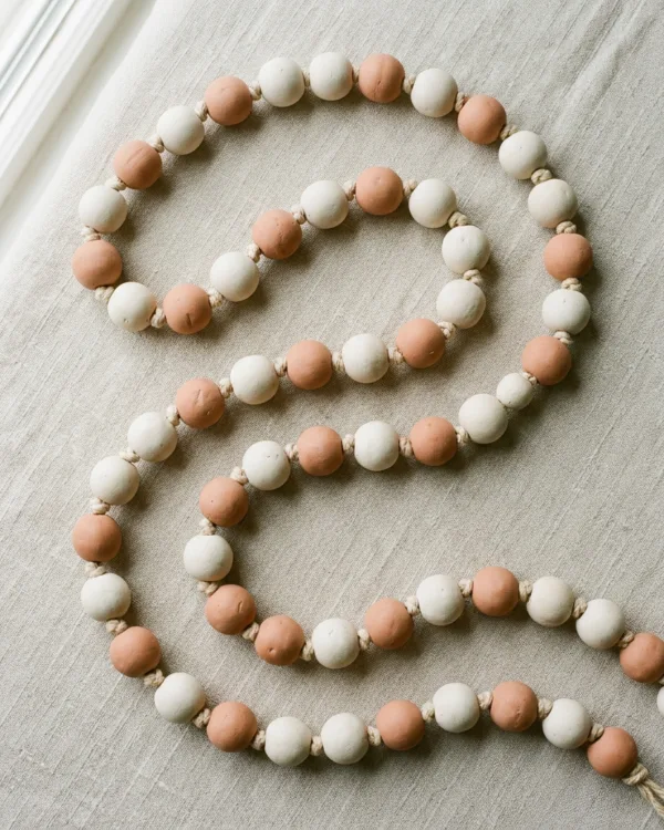 Garland of round white and terracotta clay beads knotted onto cotton cord