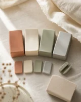 Four blocks of polymer clay in muted colours with baked test tiles, one snapped in half